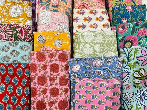 A jumble of folded blockprinted cottons in many different prints and colours