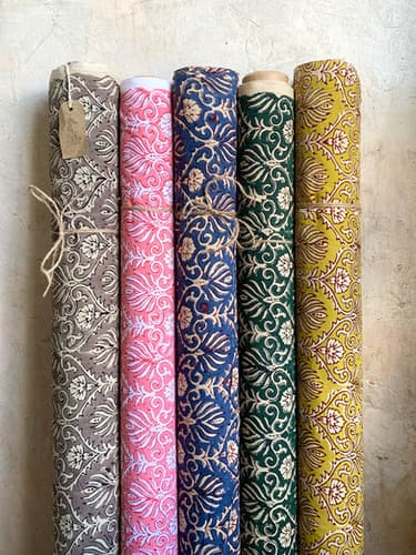 Five bolts of blockprinted cotton stood in a row, one tied with string