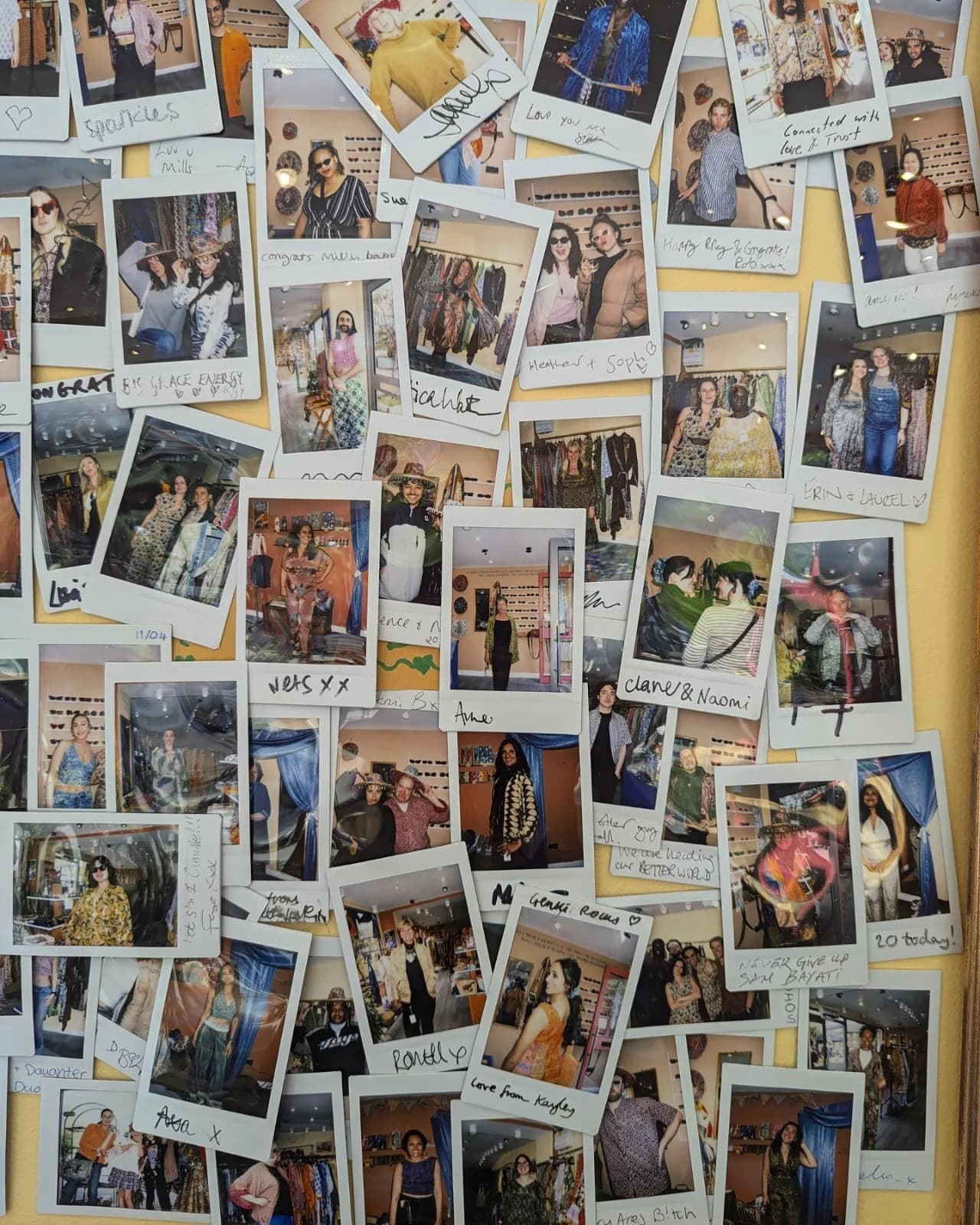A wall covered in signed polaroids of customers wearing Genki